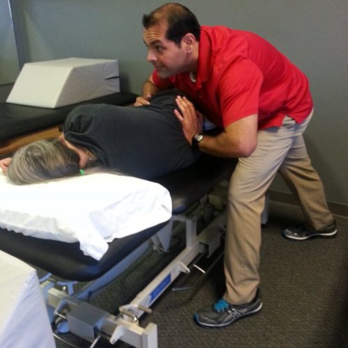 Amit leaning in to apply traction to the lumbosacral joint to improve spine mobility and decrease pain.